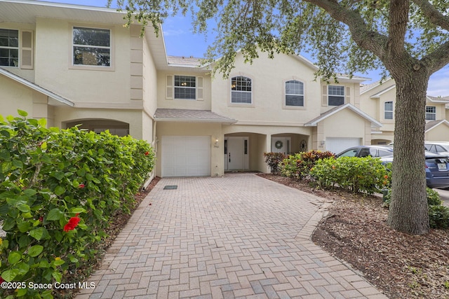 7961 Evelyn Ct, Cape Canaveral, FL 32920 - townhome / multi-family property featuring a garage, stucco siding, and decorative driveway
