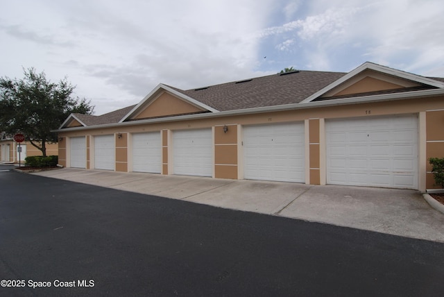 3868 Lexmark Ln Unit 205, Rockledge, FL 32955 - view of front facade featuring community garages and a shingled roof