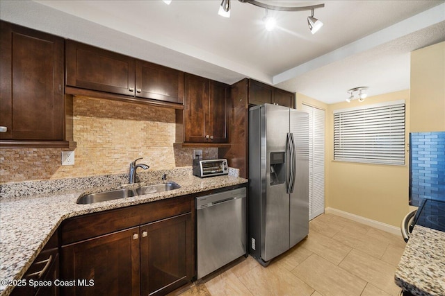 4100 Ocean Beach Blvd Unit 210, Cocoa Beach, FL 32931 - kitchen featuring appliances with stainless steel finishes, a sink, baseboards, dark brown cabinets, and backsplash