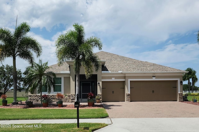 5852 Goleta Cir, Melbourne, FL 32940 - view of front of property featuring a garage, stone siding, driveway, and stucco siding