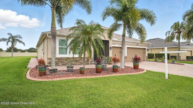 5852 Goleta Cir, Melbourne, FL 32940 - view of front of property featuring an attached garage, stucco siding, driveway, a front yard, and a shingled roof