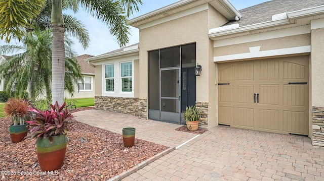 5852 Goleta Cir, Melbourne, FL 32940 - doorway to property with stucco siding, stone siding, a garage, and decorative driveway