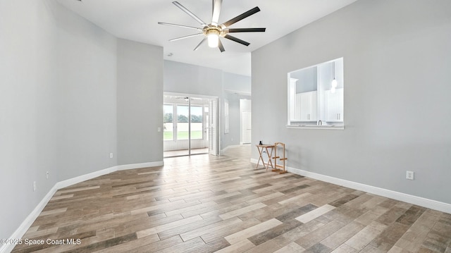 5852 Goleta Cir, Melbourne, FL 32940 - unfurnished room featuring a ceiling fan, light wood-style floors, a towering ceiling, and baseboards