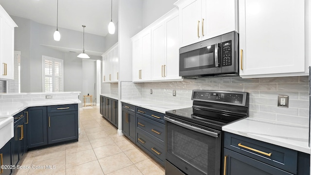 5852 Goleta Cir, Melbourne, FL 32940 - kitchen with stainless steel microwave, black electric range oven, white cabinets, and tasteful backsplash