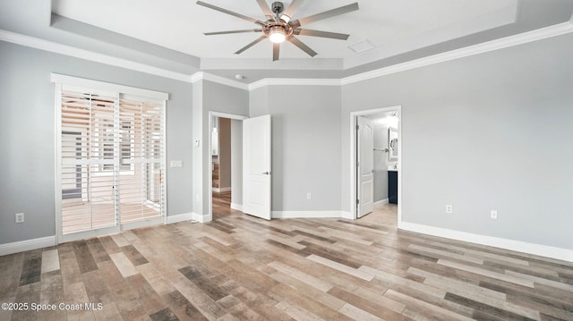 5852 Goleta Cir, Melbourne, FL 32940 - unfurnished bedroom with a tray ceiling, wood finished floors, baseboards, access to outside, and ensuite bath