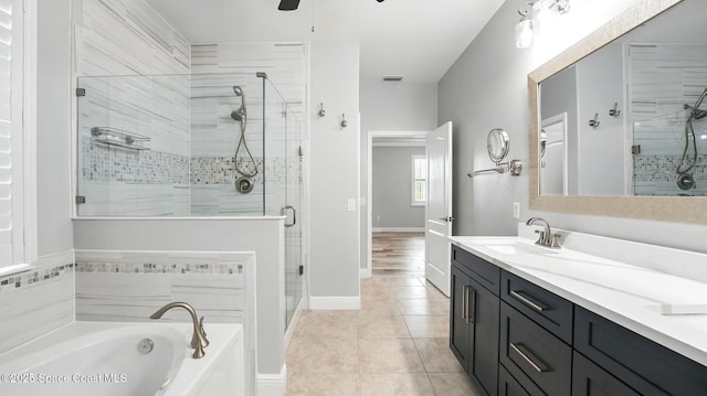 5852 Goleta Cir, Melbourne, FL 32940 - bathroom featuring double vanity, a stall shower, a garden tub, tile patterned flooring, and baseboards