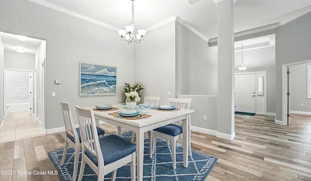 5852 Goleta Cir, Melbourne, FL 32940 - dining area featuring a chandelier, light wood-type flooring, ornamental molding, baseboards, and a high ceiling