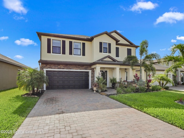 4647 Broomsedge Cir, West Melbourne, FL 32904 - view of front facade featuring stucco siding, decorative driveway, an attached garage, a front lawn, and stone siding