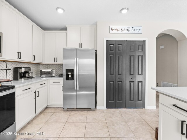 4647 Broomsedge Cir, West Melbourne, FL 32904 - kitchen with stainless steel fridge, electric stove, arched walkways, light countertops, and recessed lighting
