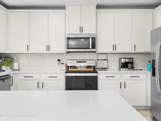 4647 Broomsedge Cir, West Melbourne, FL 32904 - kitchen with stainless steel appliances, light countertops, backsplash, and white cabinets