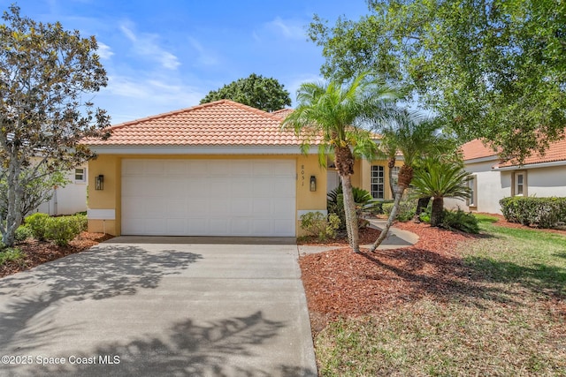 8051 Daventry Dr, Melbourne, FL 32940 - mediterranean / spanish-style house with a garage, driveway, stucco siding, and a tile roof