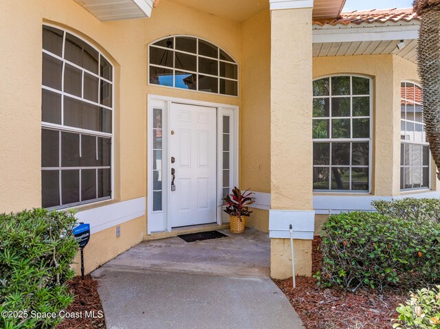 8051 Daventry Dr, Melbourne, FL 32940 - doorway to property featuring stucco siding and a porch