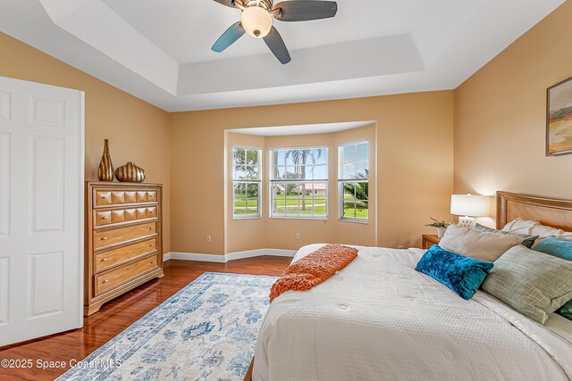 8051 Daventry Dr, Melbourne, FL 32940 - bedroom with a tray ceiling, wood finished floors, ceiling fan, and baseboards