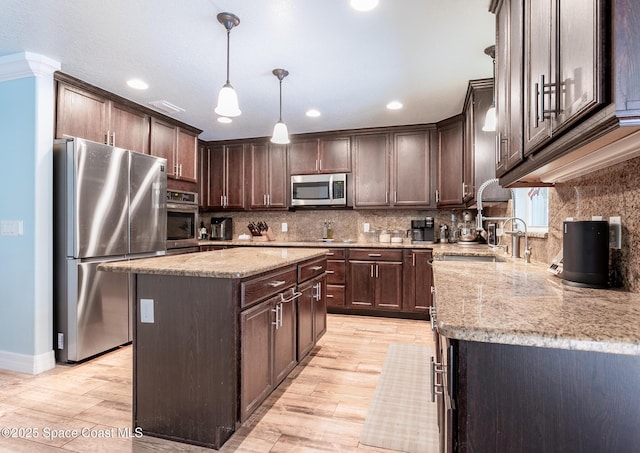 2501 Eldron Blvd SE, Palm Bay, FL 32909 - kitchen with stainless steel appliances, a sink, dark brown cabinetry, light stone countertops, and recessed lighting