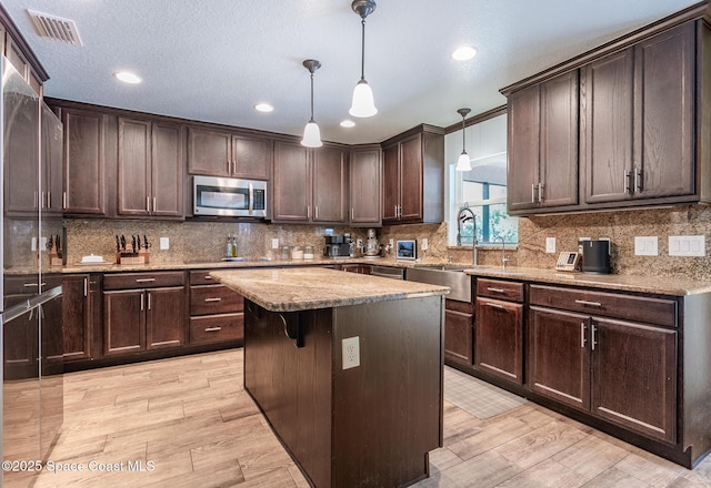 2501 Eldron Blvd SE, Palm Bay, FL 32909 - kitchen with appliances with stainless steel finishes, a sink, light wood finished floors, dark brown cabinetry, and recessed lighting