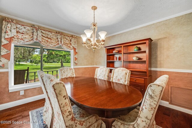 2280 Grove St, Titusville, FL 32796 - dining room with a chandelier, crown molding, wood finished floors, and baseboards