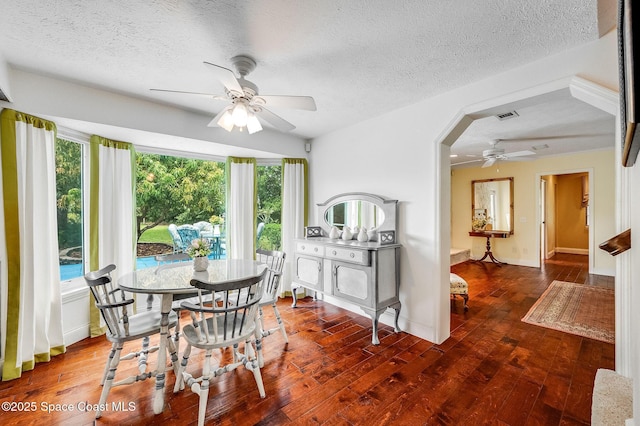 2280 Grove St, Titusville, FL 32796 - dining area featuring a ceiling fan, a textured ceiling, wood finished floors, arched walkways, and baseboards