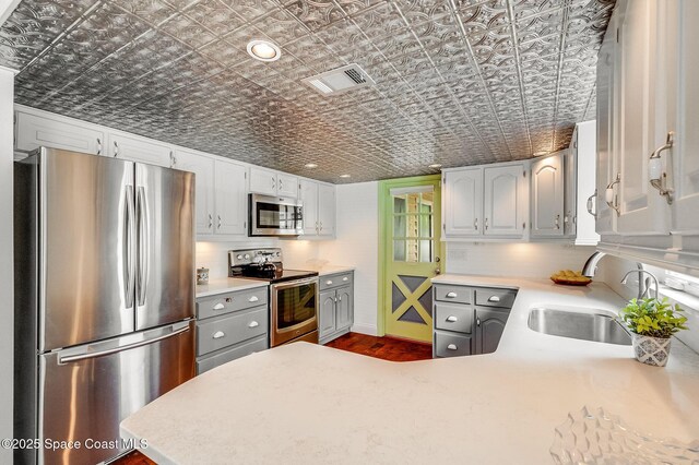 2280 Grove St, Titusville, FL 32796 - kitchen with stainless steel appliances, an ornate ceiling, a sink, light countertops, and a peninsula