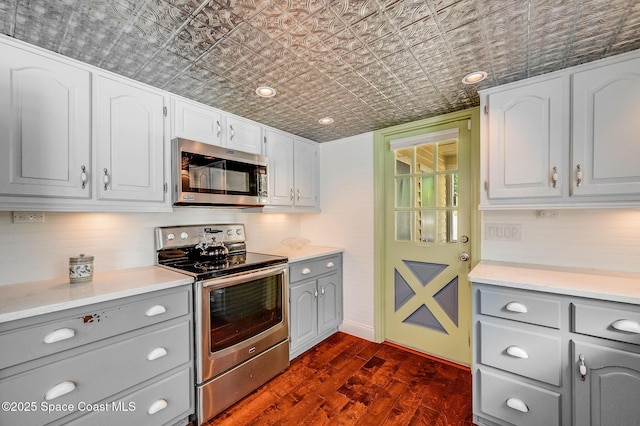 2280 Grove St, Titusville, FL 32796 - kitchen featuring appliances with stainless steel finishes, gray cabinets, an ornate ceiling, and dark wood-style floors