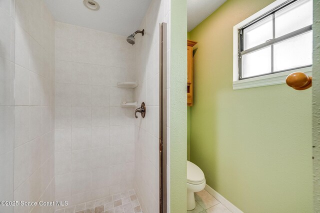 2280 Grove St, Titusville, FL 32796 - bathroom with tiled shower, toilet, and tile patterned floors