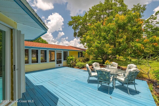 2280 Grove St, Titusville, FL 32796 - wooden terrace with outdoor dining area and a sunroom