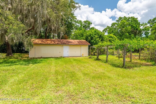 2280 Grove St, Titusville, FL 32796 - view of grassy yard with an outbuilding and a detached garage