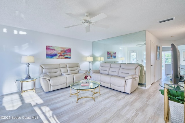 70 Royal Oak Ct Unit 206, Vero Beach, FL 32962 - living room featuring ceiling fan, light wood-type flooring, a textured ceiling, and baseboards