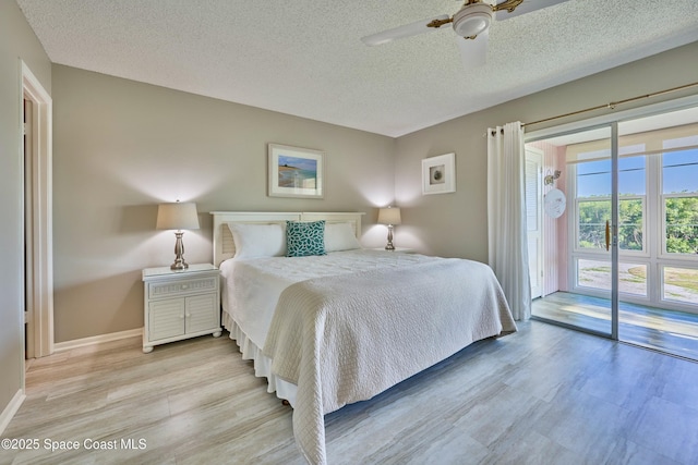 70 Royal Oak Ct Unit 206, Vero Beach, FL 32962 - bedroom featuring access to exterior, a textured ceiling, light wood finished floors, baseboards, and ceiling fan