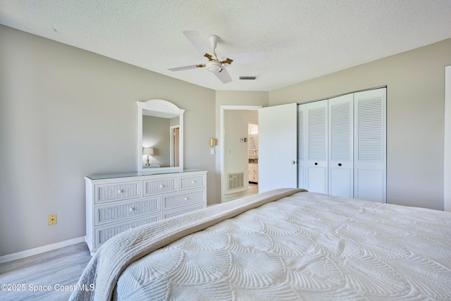 70 Royal Oak Ct Unit 206, Vero Beach, FL 32962 - bedroom with light wood finished floors, a textured ceiling, a closet, baseboards, and ceiling fan