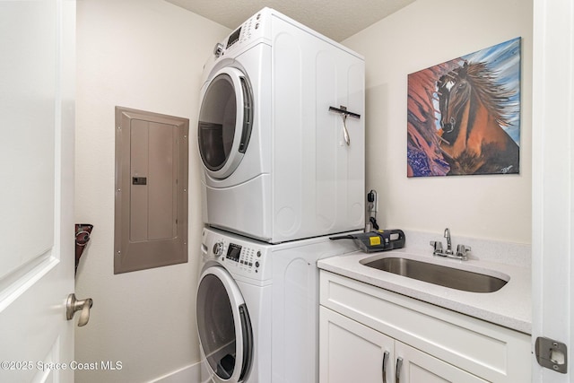 6015 Turtle Beach Ln Unit 204, Cocoa Beach, FL 32931 - laundry area featuring stacked washer / drying machine, electric panel, and cabinet space