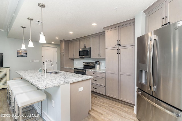 6015 Turtle Beach Ln Unit 204, Cocoa Beach, FL 32931 - kitchen with appliances with stainless steel finishes, a sink, light wood finished floors, a center island with sink, and a kitchen breakfast bar