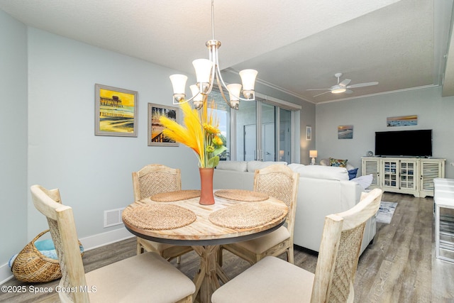 6015 Turtle Beach Ln Unit 204, Cocoa Beach, FL 32931 - dining room featuring wood finished floors, ceiling fan, crown molding, baseboards, and a chandelier