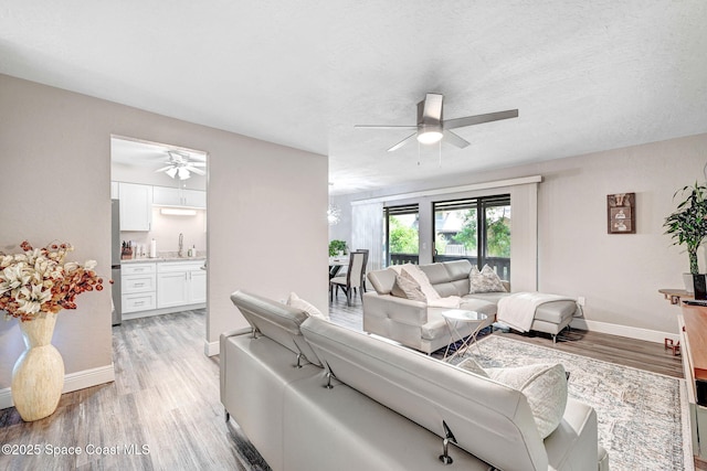 9040 York Ln Unit 16G, West Melbourne, FL 32904 - living area with a ceiling fan, light wood-type flooring, and baseboards