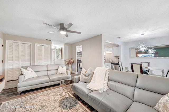 9040 York Ln Unit 16G, West Melbourne, FL 32904 - living area with wood finished floors, ceiling fan, a textured ceiling, baseboards, and a chandelier