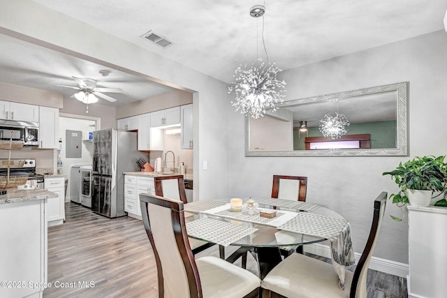 9040 York Ln Unit 16G, West Melbourne, FL 32904 - dining space with washer and dryer, light wood-style floors, a chandelier, electric panel, and a ceiling fan