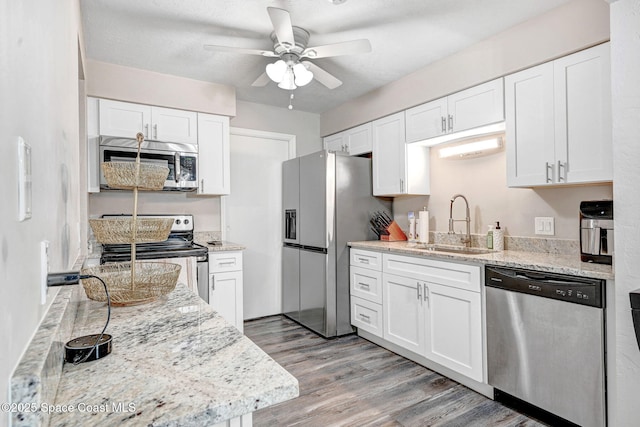 9040 York Ln Unit 16G, West Melbourne, FL 32904 - kitchen featuring stainless steel appliances, a ceiling fan, a sink, light wood-style floors, and white cabinetry