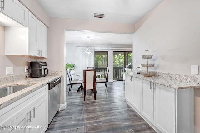 9040 York Ln Unit 16G, West Melbourne, FL 32904 - kitchen with stainless steel dishwasher, white cabinetry, dark wood-style flooring, a chandelier, and light stone counters