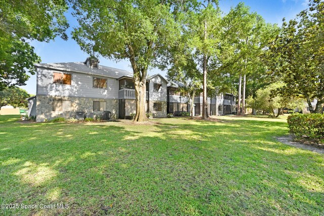 9040 York Ln Unit 16G, West Melbourne, FL 32904 - back of house with stone siding and a yard