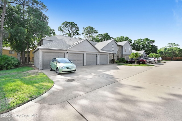 9040 York Ln Unit 16G, West Melbourne, FL 32904 - view of front of home featuring driveway, an attached garage, a front lawn, and stone siding