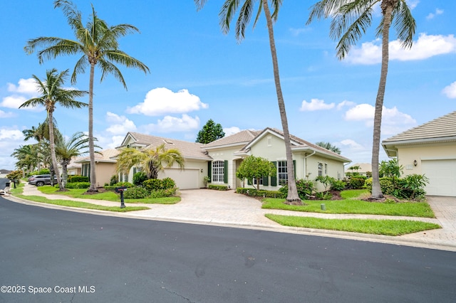274 Clyde St, Melbourne Beach, FL 32951 - view of front of home featuring stucco siding, driveway, a garage, and a tiled roof
