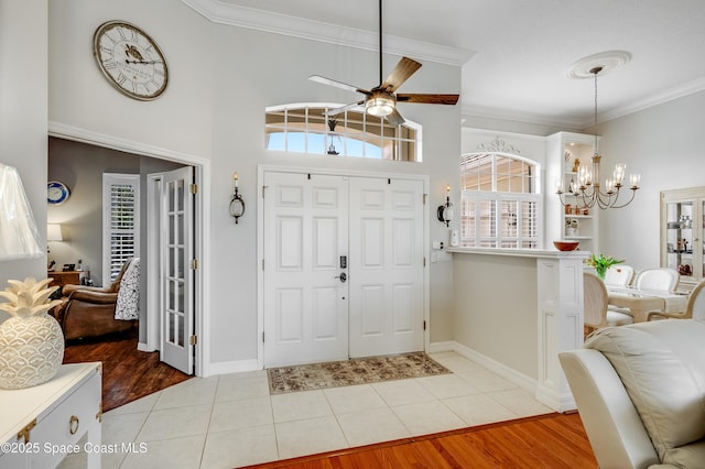 274 Clyde St, Melbourne Beach, FL 32951 - foyer featuring a chandelier, ceiling fan, crown molding, light tile patterned floors, and baseboards