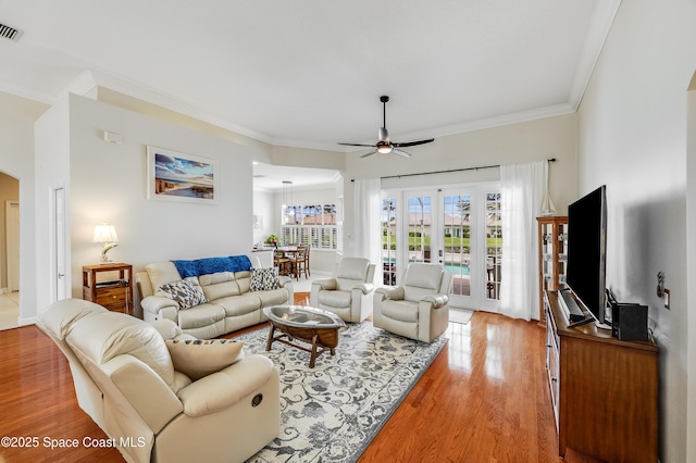 274 Clyde St, Melbourne Beach, FL 32951 - living area featuring a ceiling fan, light wood finished floors, arched walkways, and crown molding