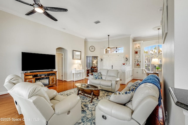 274 Clyde St, Melbourne Beach, FL 32951 - living area featuring ceiling fan, wood finished floors, ornamental molding, arched walkways, and a chandelier