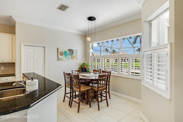 274 Clyde St, Melbourne Beach, FL 32951 - dining area with crown molding, light tile patterned flooring, baseboards, and a textured ceiling