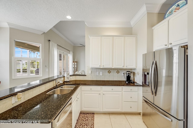 274 Clyde St, Melbourne Beach, FL 32951 - kitchen featuring stainless steel appliances, a sink, dark stone counters, light tile patterned floors, and white cabinets