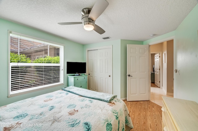 274 Clyde St, Melbourne Beach, FL 32951 - bedroom with a textured ceiling, light wood-style flooring, a closet, ceiling fan, and baseboards
