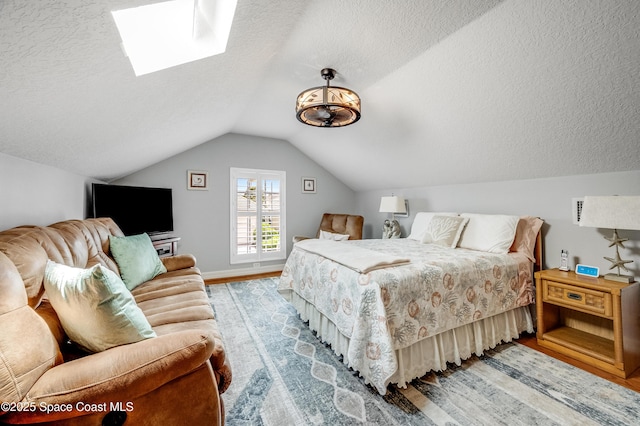 274 Clyde St, Melbourne Beach, FL 32951 - bedroom with wood finished floors, a textured ceiling, a skylight, vaulted ceiling, and baseboards