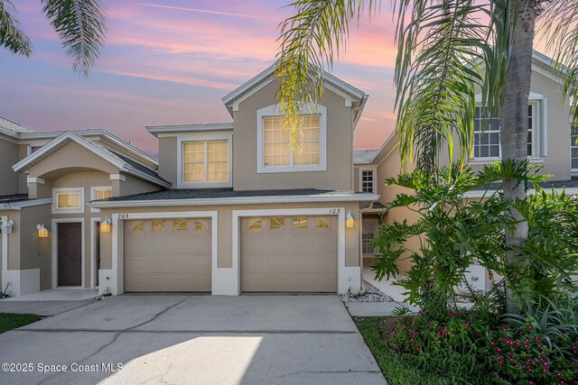 401 Trotter Ln Unit 103, Melbourne, FL 32940 - traditional-style house featuring stucco siding, driveway, and a garage