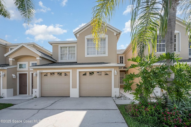 401 Trotter Ln Unit 103, Melbourne, FL 32940 - view of front of property featuring stucco siding, driveway, and a garage