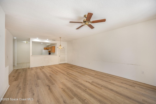 401 Trotter Ln Unit 103, Melbourne, FL 32940 - unfurnished living room featuring light wood-style floors, a ceiling fan, and a textured ceiling